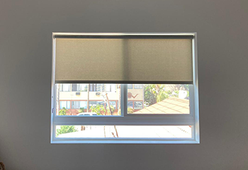 Simple roller shades installed on living room windows, enhancing the ambiance of the space in Dana Point.